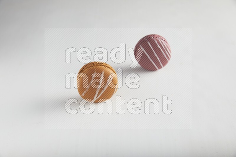 45º Shot of of two assorted Brown Irish Cream, and Red Poppy Flower macarons on white background