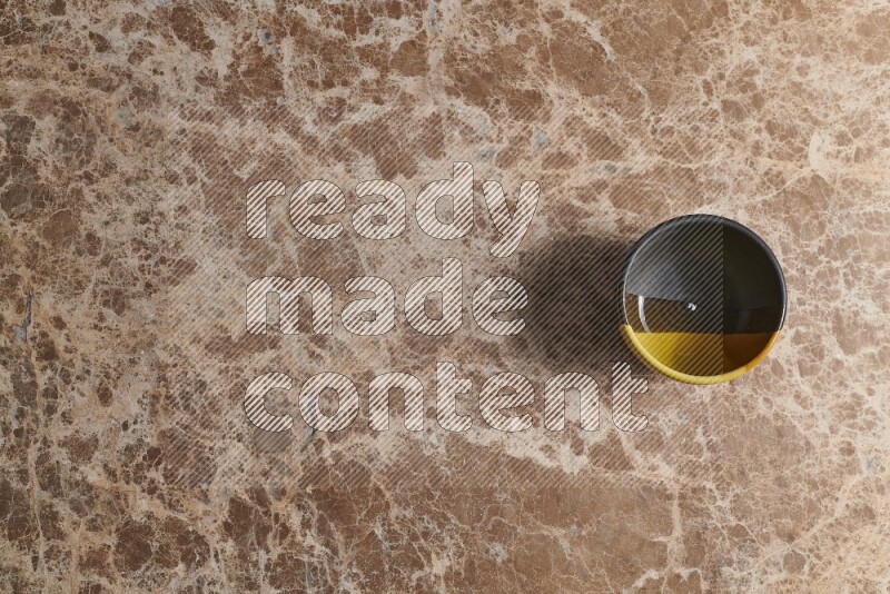 A multicolored pottery bowl on beige marble background