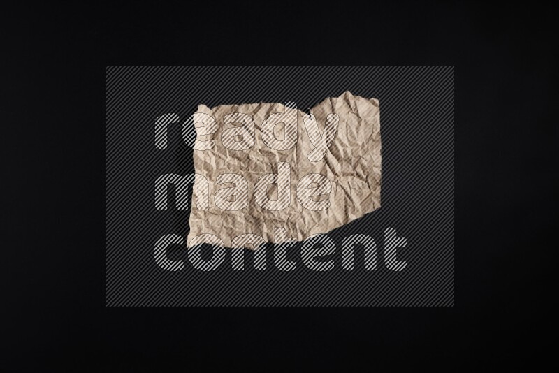 Crumpled craft paper on black background
