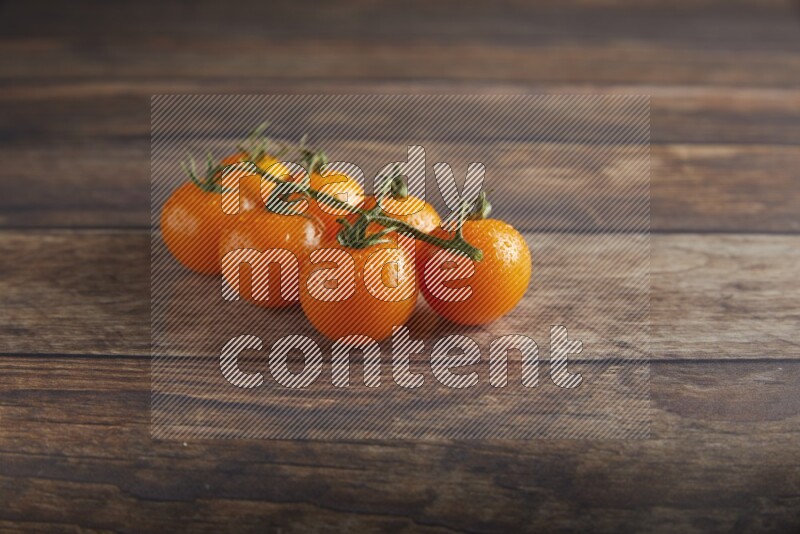 Orange cherry tomato vein on a textured wooden background 45 degree