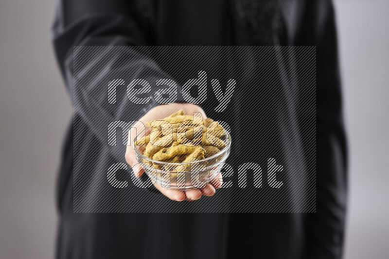 Woman in abaya holding different kinds of spices in different positions