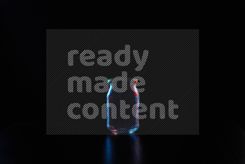 Glassware with rim light in red and blue against black background