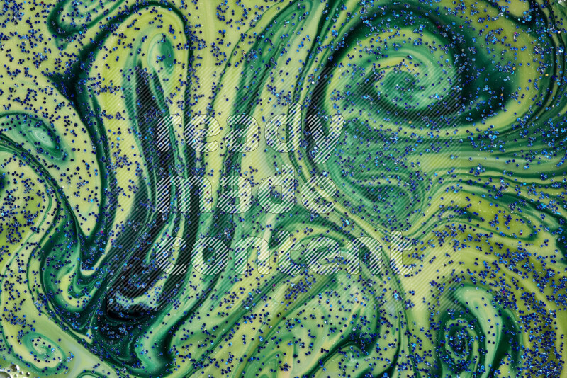 A close-up of sparkling blue glitter scattered on swirling blue and green background
