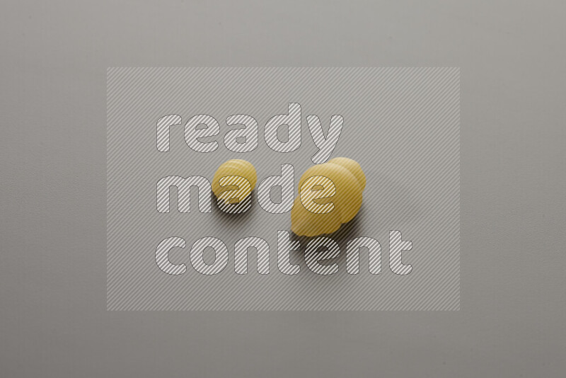 Shells pasta with other types of pasta on grey background