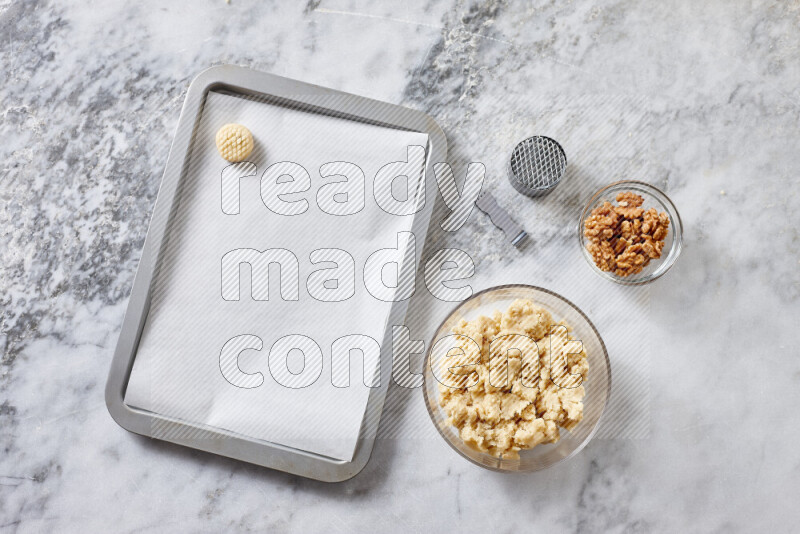 Kahk step by step with its ingredients ghee, sugar, flour, sesame, yeast, water and kahk flavor on grey marble background