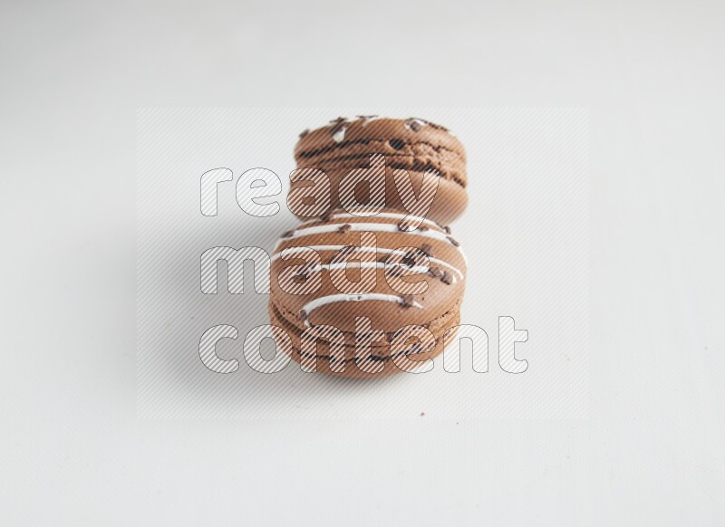 45º Shot of two Brown white Chocolate Caramel macarons on white background