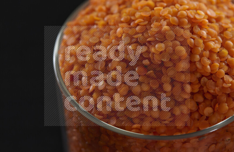 Lentils in a glass jar on black background