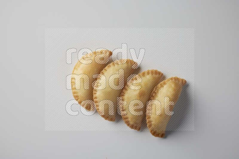 Four fried sambosa from a top angle on a white background