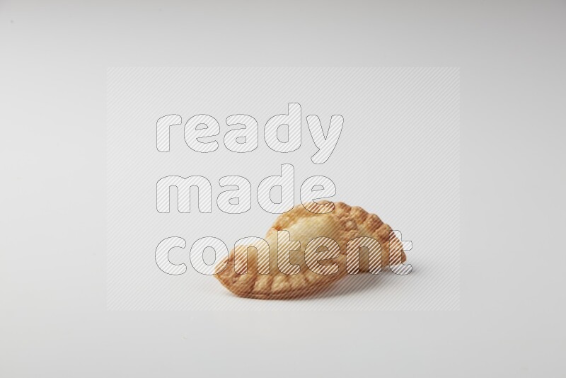Two fried sambosas on a white background