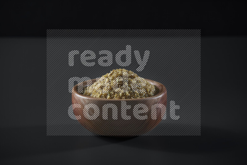 Coarse bulgur in a wooden bowl on grey background