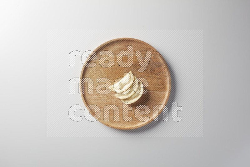 Three Sambosas on a wooden round plate on a white background
