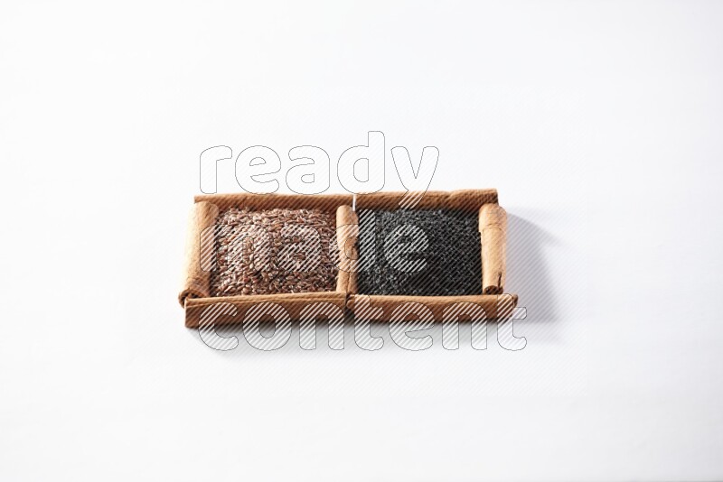 2 squares of cinnamon sticks full of flaxseeds and black seeds on white flooring