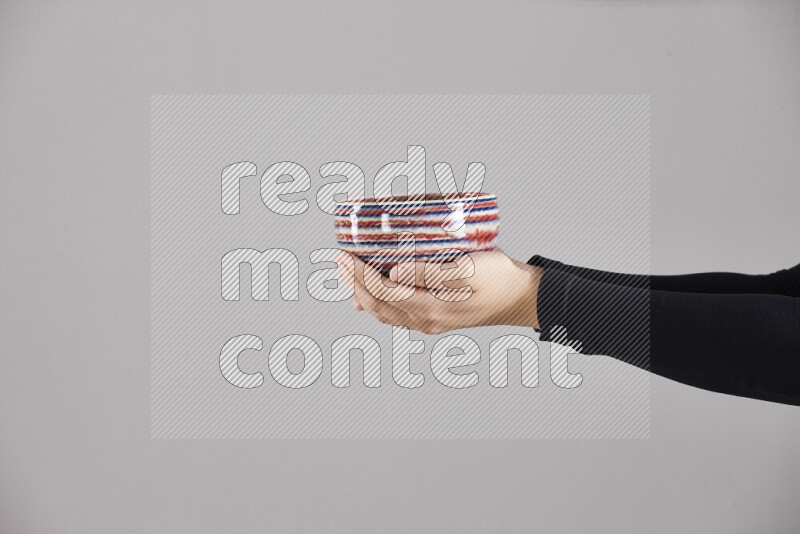 امرأة ترتدي عباءة سوداء تحمل أدوات فخارية مختلفة في أوضاع متعددة