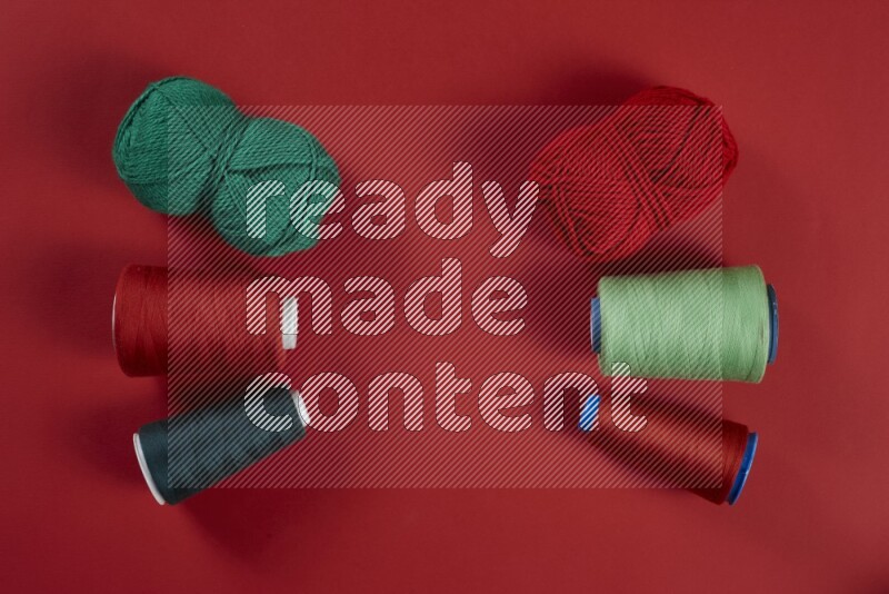 A green and red collection of sewing and tailoring tools arranged on a red background