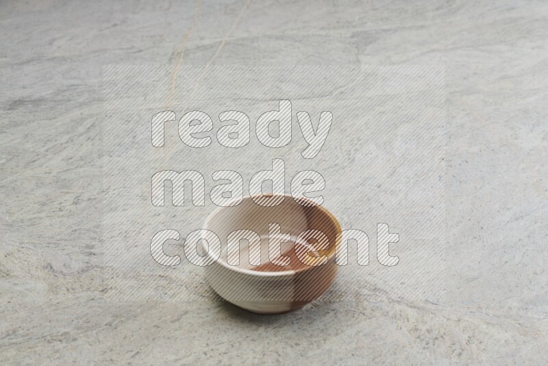 A multicolored pottery bowl on grey marble background