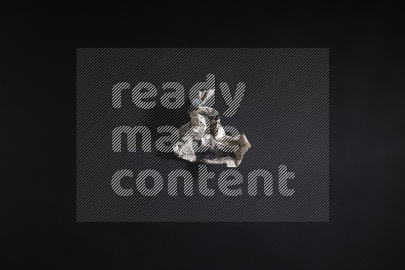 Crumpled newspaper sheet on black background