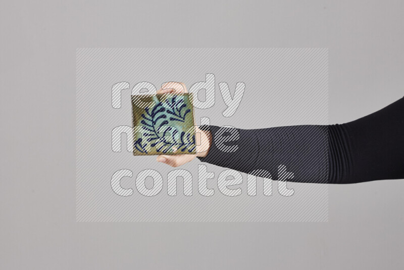 A woman in black abaya holding different pottery essentials in different positions