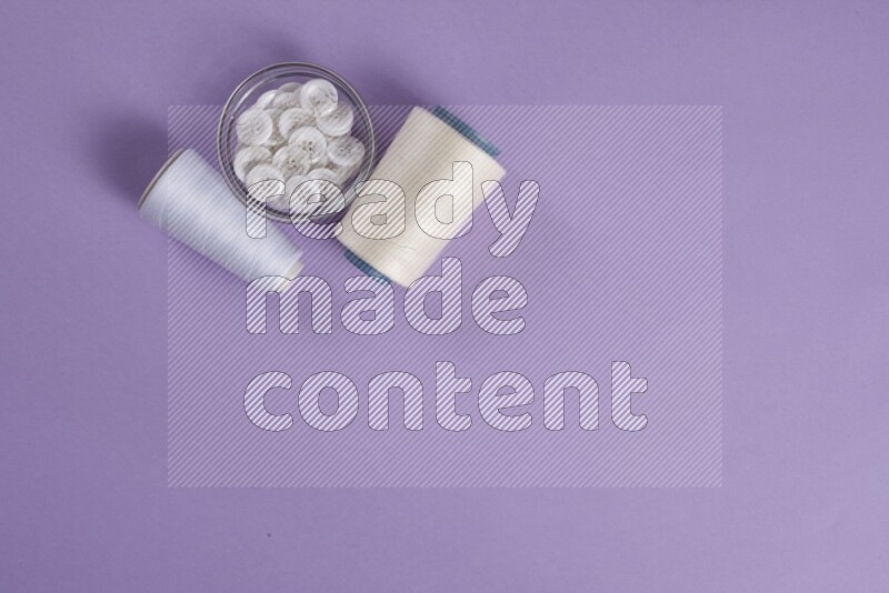 A white and purple collection of sewing and tailoring tools arranged on a purple background