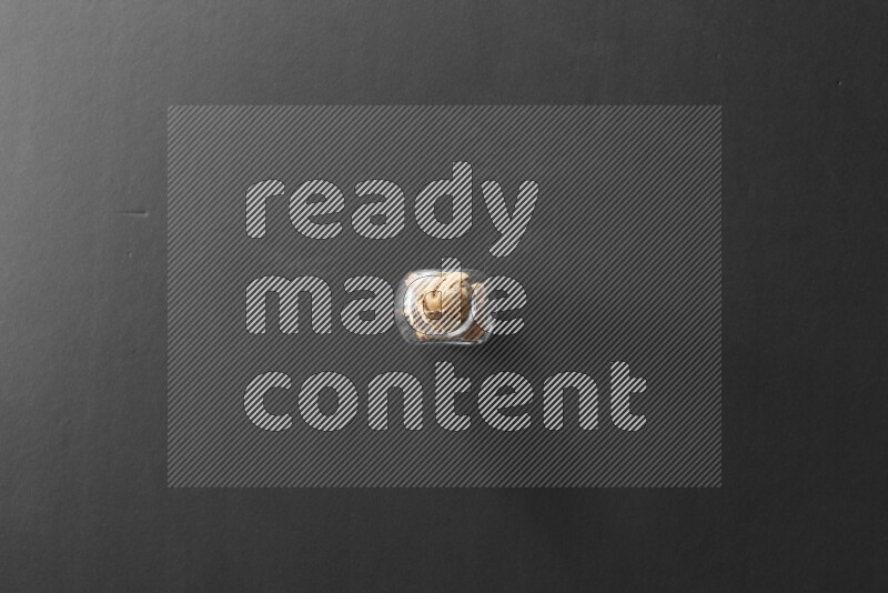 زنجبيل مجفف في وعاء زجاجي علي خلفية سوداء