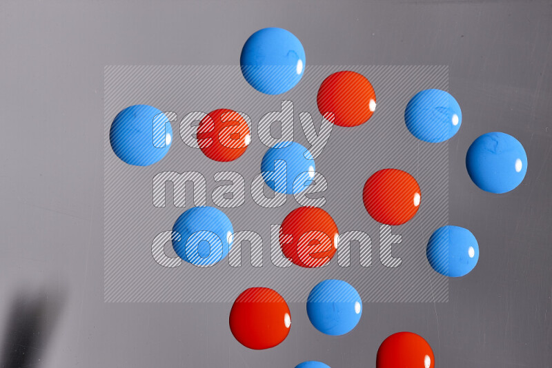 Close-ups of abstract red and blue paint droplets on the surface