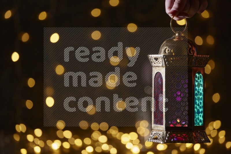 A traditional ramadan lantern surrounded by glowing fairy lights in a dark setup
