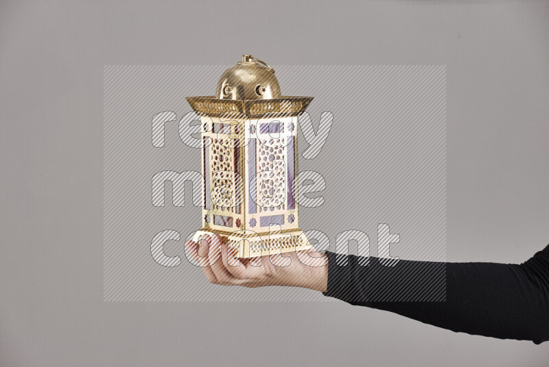 A woman in black abaya holding different ramadan lanterns in different positions