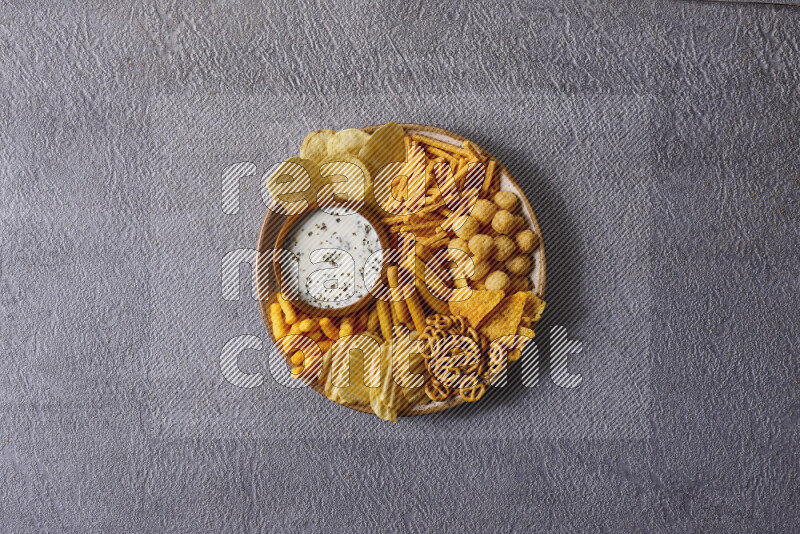 Assorted snacks in pottery bowls on grey background