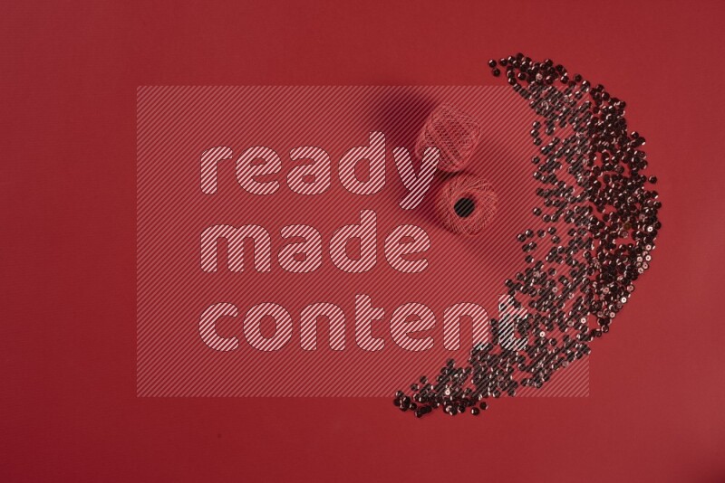 A red collection of sewing and tailoring tools arranged on a red background