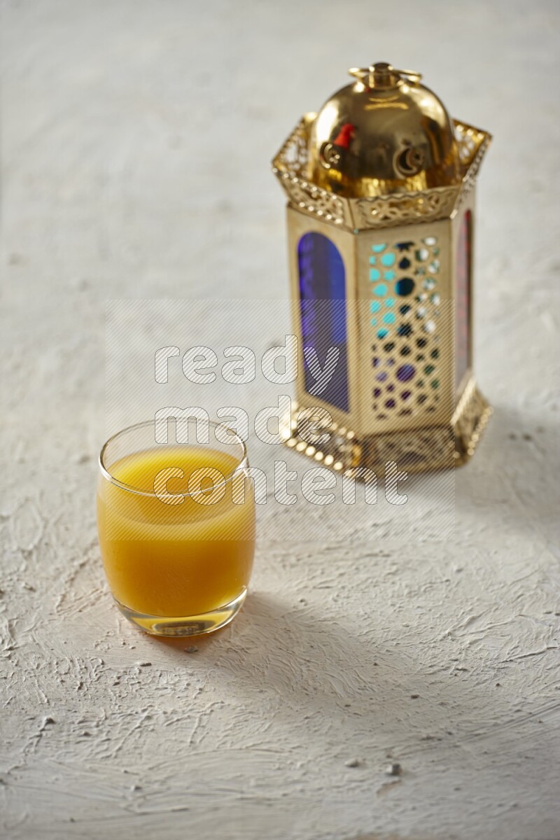 A golden lantern with different drinks, dates, nuts, prayer beads and quran on textured white background