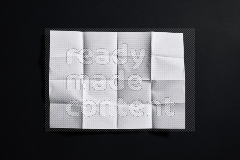 Folded notebook sheet on black background