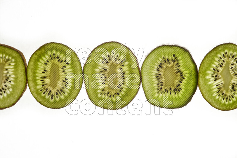 Kiwi slices on illuminated white background