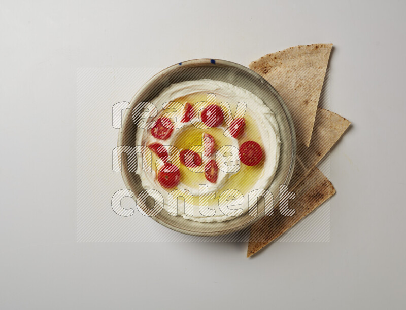 Lebnah garnished with cherry tomato in a grey pottery plate on a white background