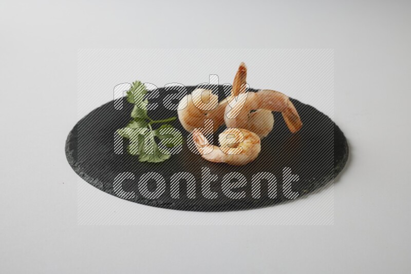 three grilled shrimp  on a black slate direct  on a white back ground
