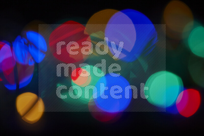 Light bulbs glowing against backdrop of multicolord bokeh