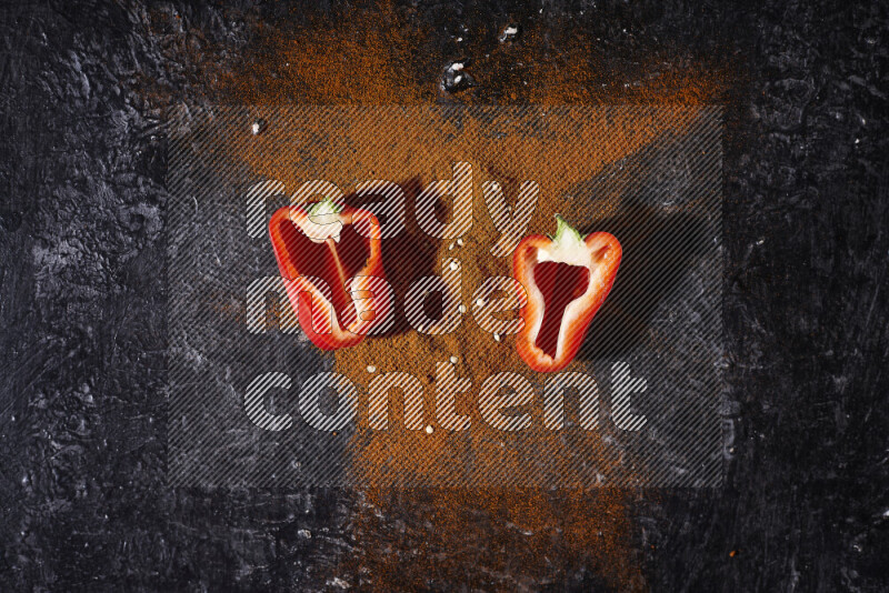 حفنة من بودرة البابريكا مع نصفين من الفلفل الأحمر الحلو على خلفية سوداء