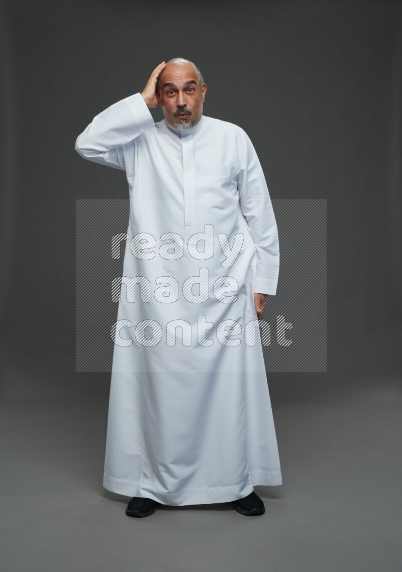 Saudi man without shomag Standing Interacting with the camera on gray background