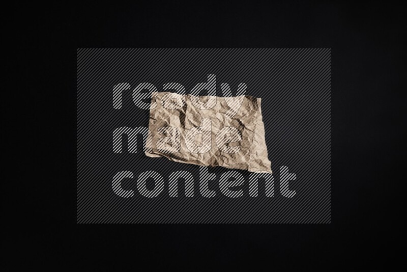 Crumpled craft paper on black background