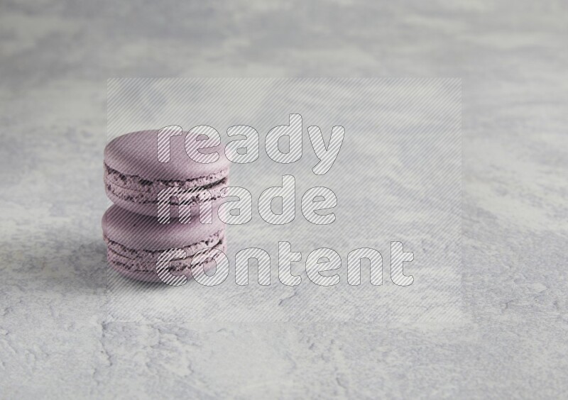45º Shot of two Purple Blueberry macarons  on white  marble background