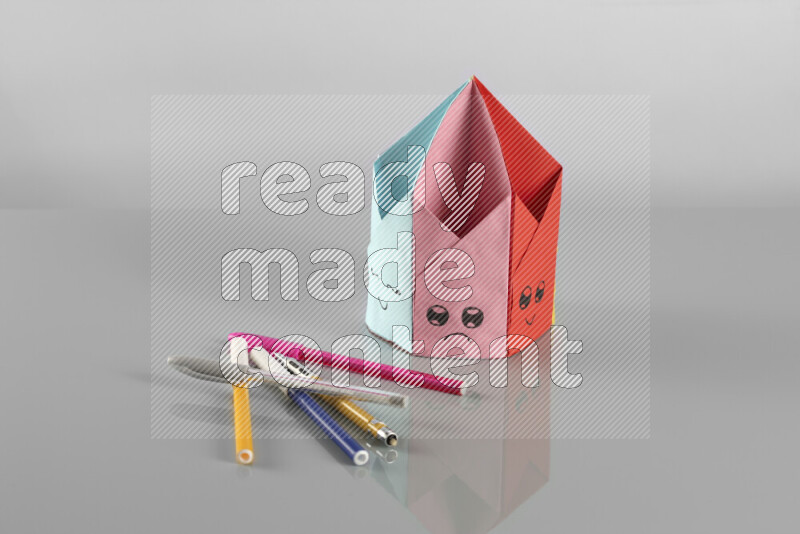 Origami pen holder on grey background