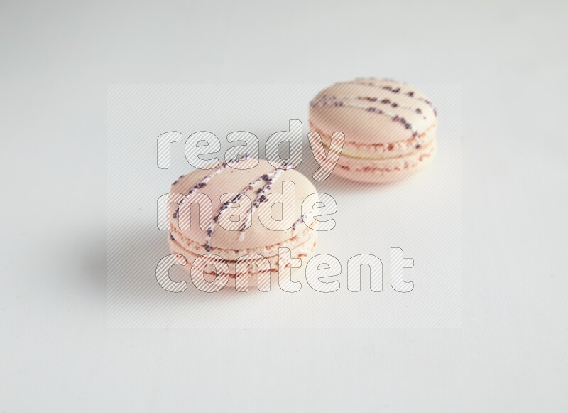 45º Shot of two pink orange blossom macarons on white background