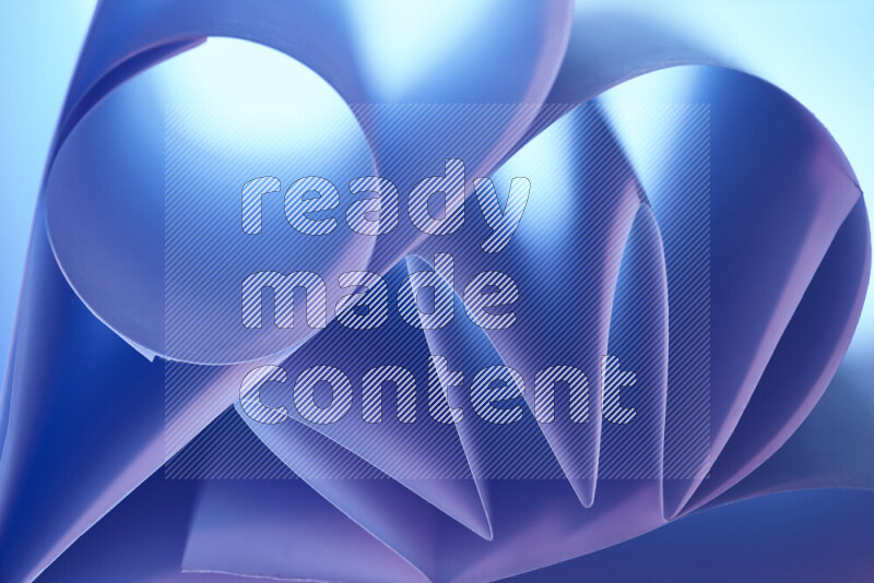 An artistic display of paper folds creating a harmonious blend of geometric shapes, highlighted by soft lighting in blue and pink tones