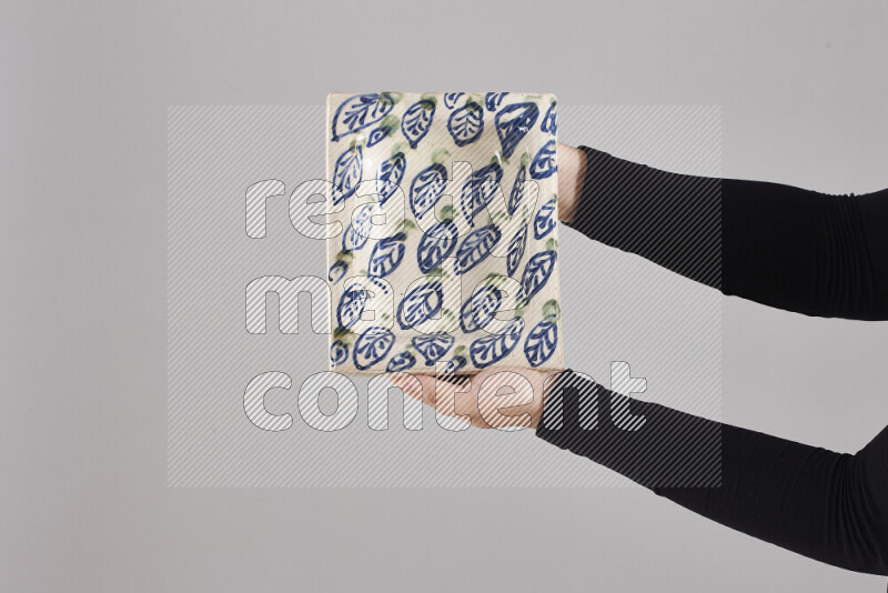 A woman in black abaya holding different pottery essentials in different positions