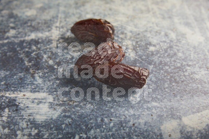 three madjoul dates on a rustic blue backround