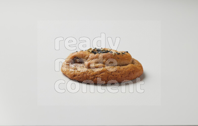 Hasawi cookie field with date and decorated by black seed and Anise grain on a white background