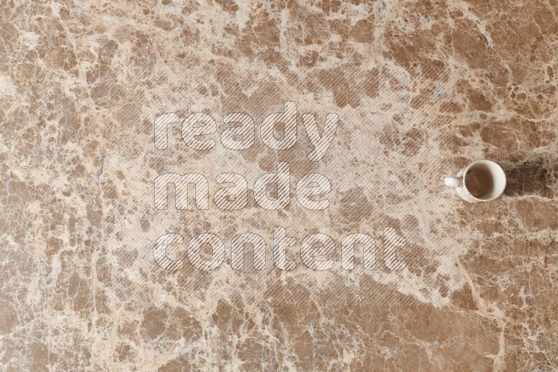 A pottery cup on beige marble background