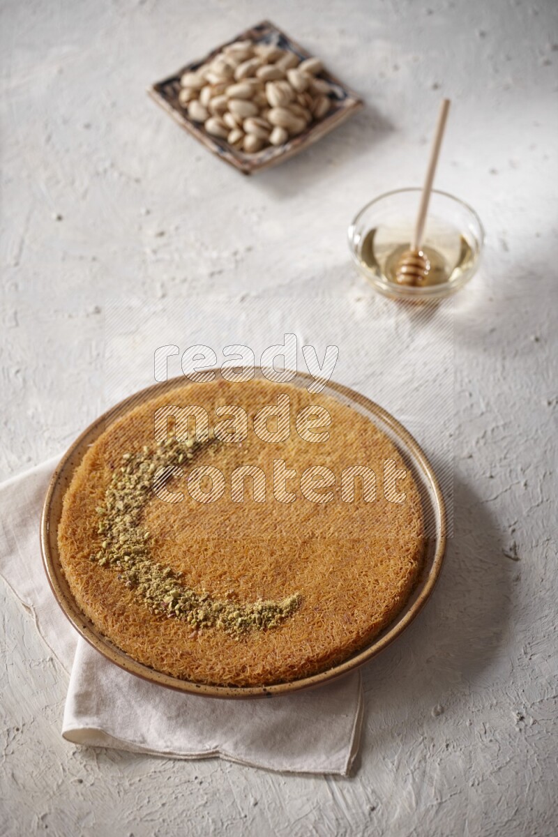 Konafa with nuts and honey in a light setup