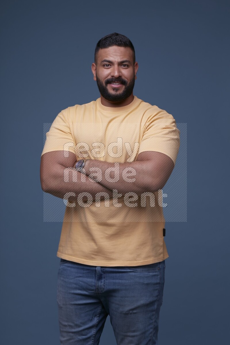 رجل يرتدي قميص اصفر بأكمام قصيرة وبنطال جينز ازرق يقف بأوضاع مختلفة