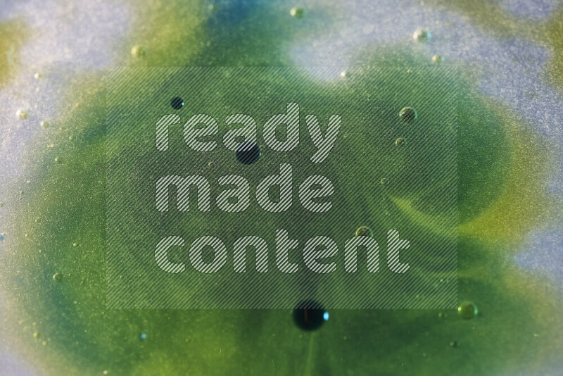 Close-ups of abstract yellow, blue and green watercolor drops on oil Surface on white background