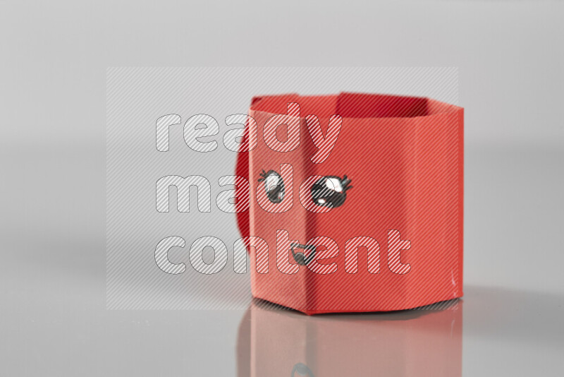 Origami cup on grey background