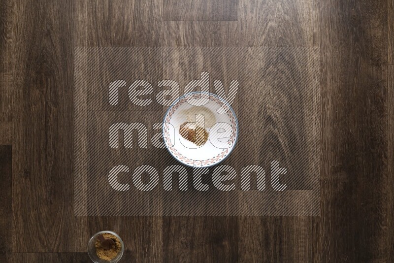 A bowl full of spices and salad dressing ingredients on wooden background